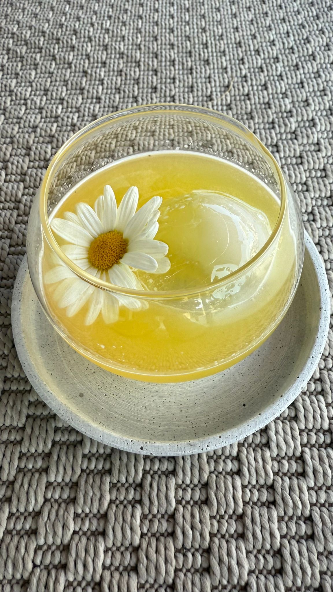 Yellow cocktail with flower garnish